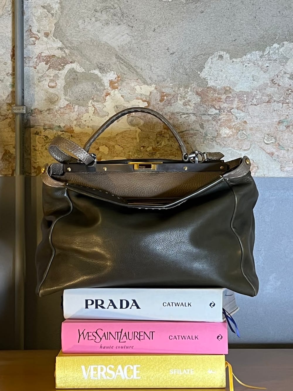 Una borsa firmata su una pila di libri di moda