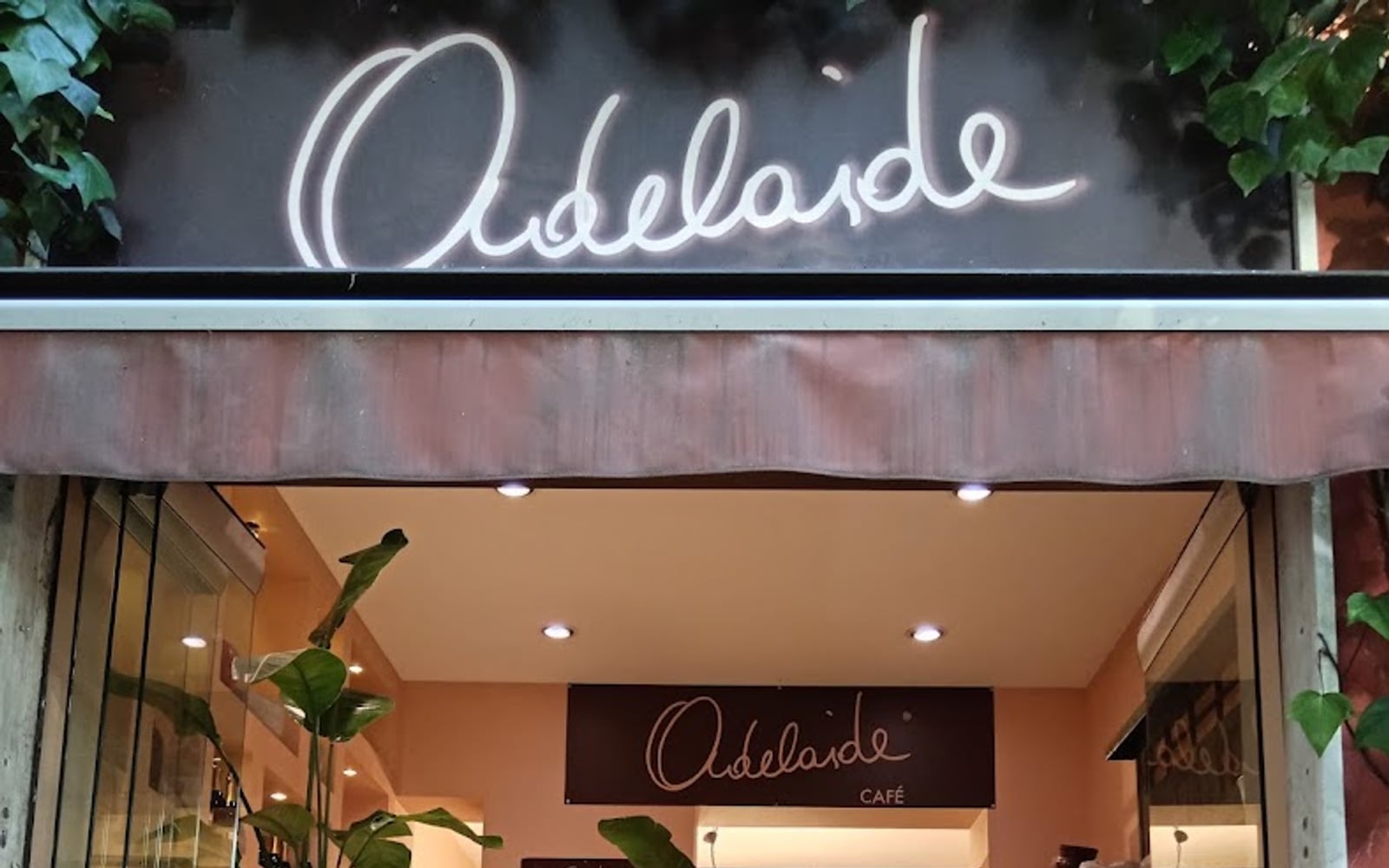 L'ingresso di Adelaide con l'insegna al neon e le cassette di frutta