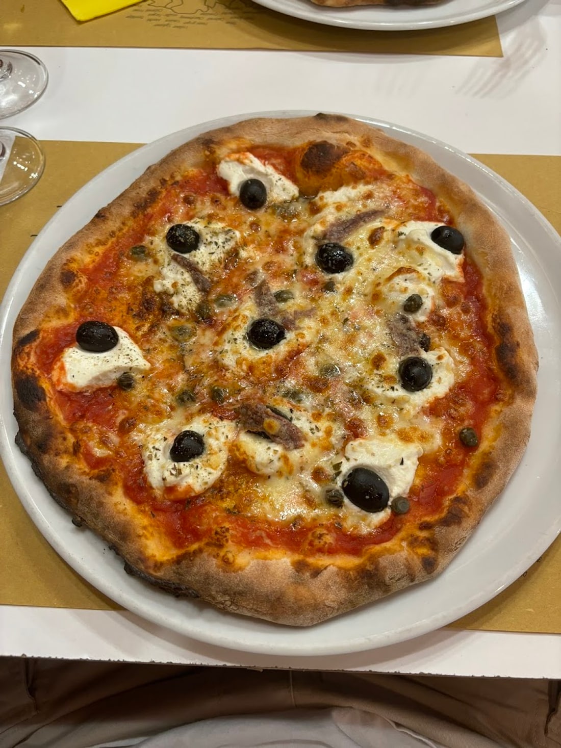 La Pizza Romana con ricotta, olive nere, capperi e acciughe