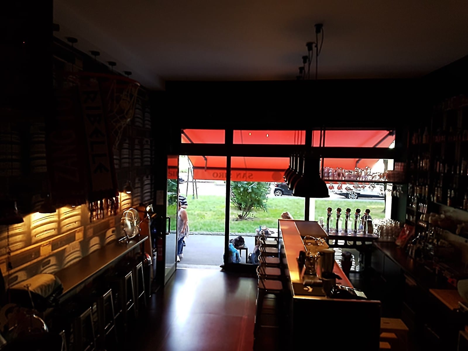 L'interno di All Beer con le spine della birra e la vetrata sulla strada