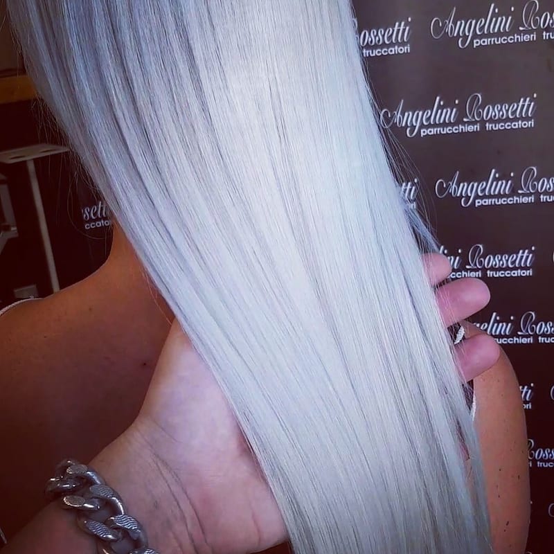 Capelli lisci platino-argento tenuti con la mano