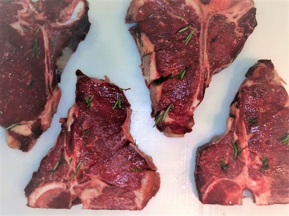 Bistecche alla fiorentina crude con rosmarino, pronte per la griglia