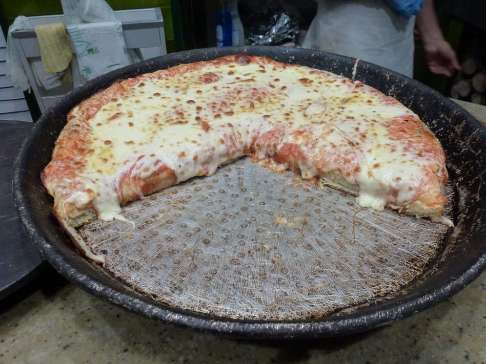 Pizza al trancio appena sfornata, crosta alta e dorata