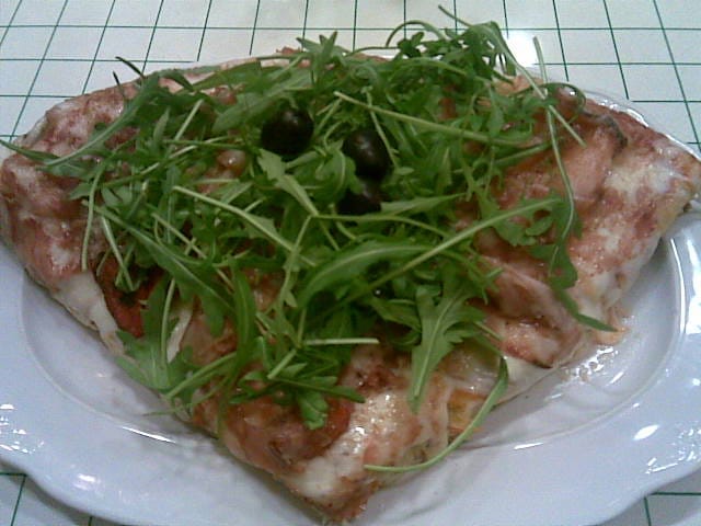 Trancio di pizza con rucola e olive