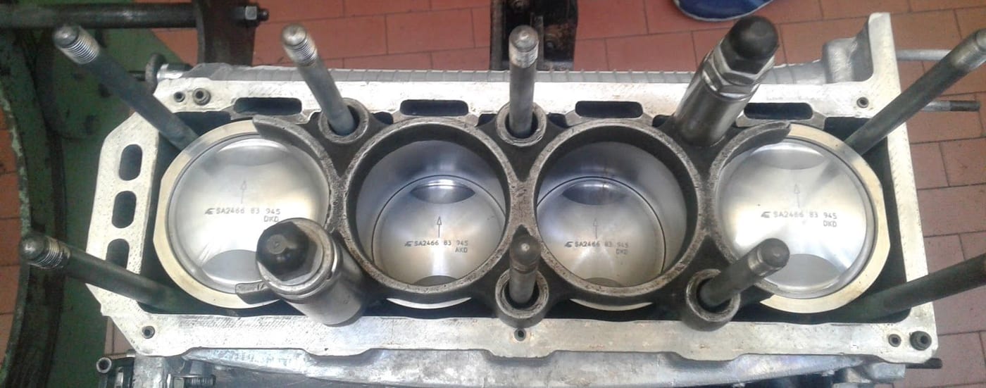 I quattro pistoni di un blocco motore aperto sul banco di lavoro