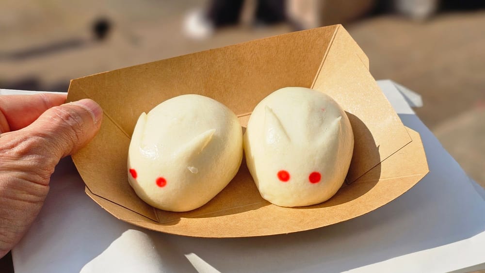 Due bao dolci a forma di coniglietto, con gli occhi rossi, nella vaschetta di kraft.