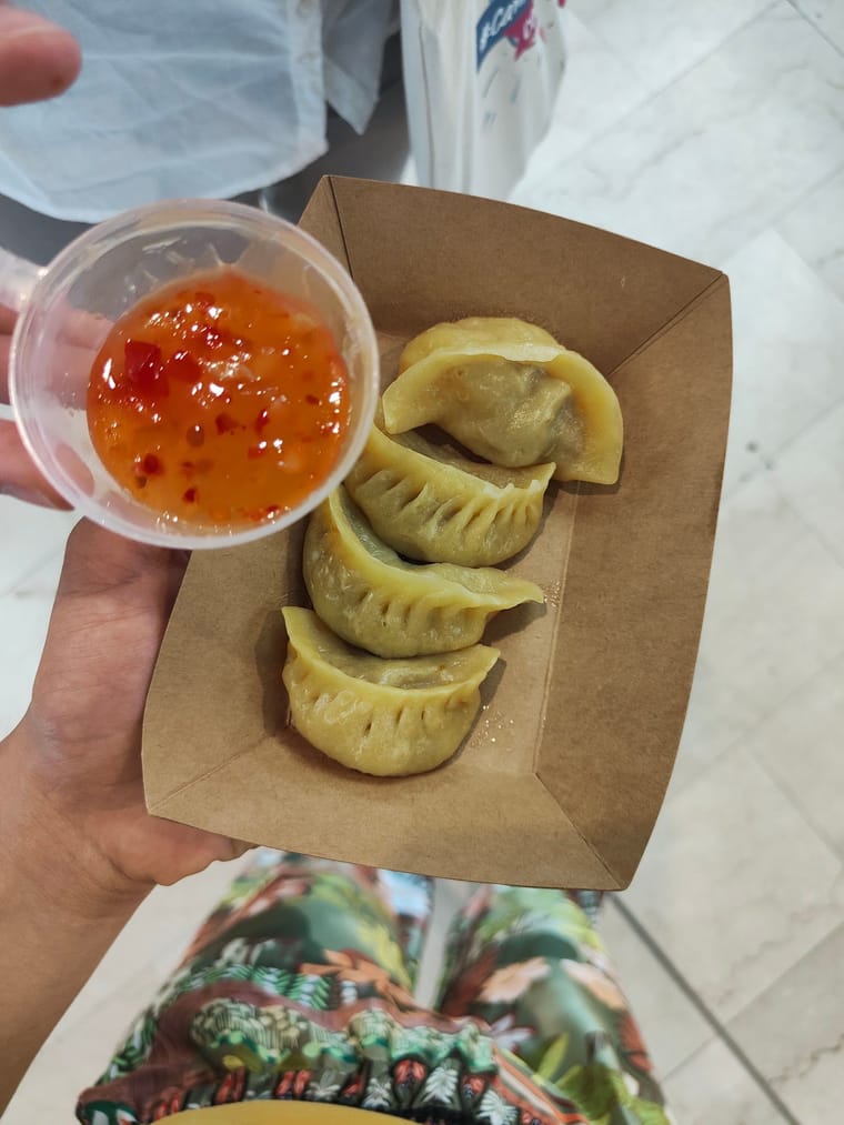 Ravioli nella vaschetta di kraft con la salsa piccante.