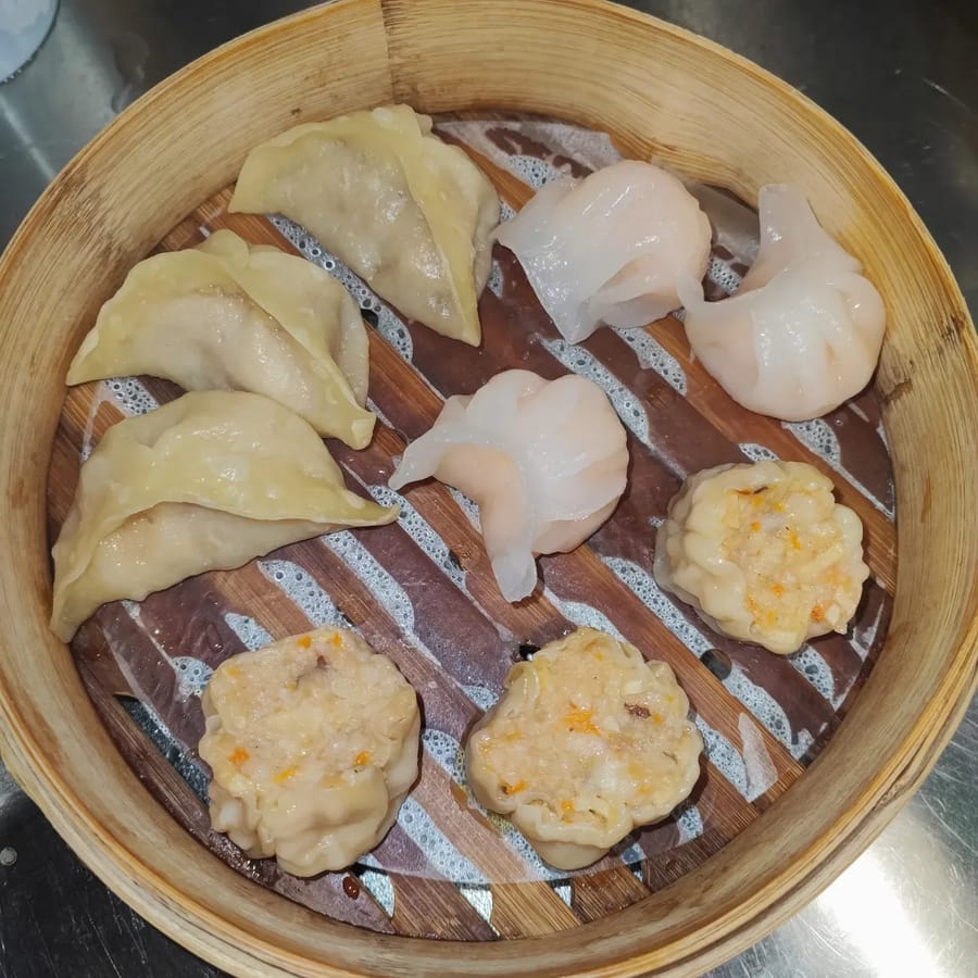 Una vaporiera di ravioli misti: a mezzaluna, cristallo coi gamberi e siumai.