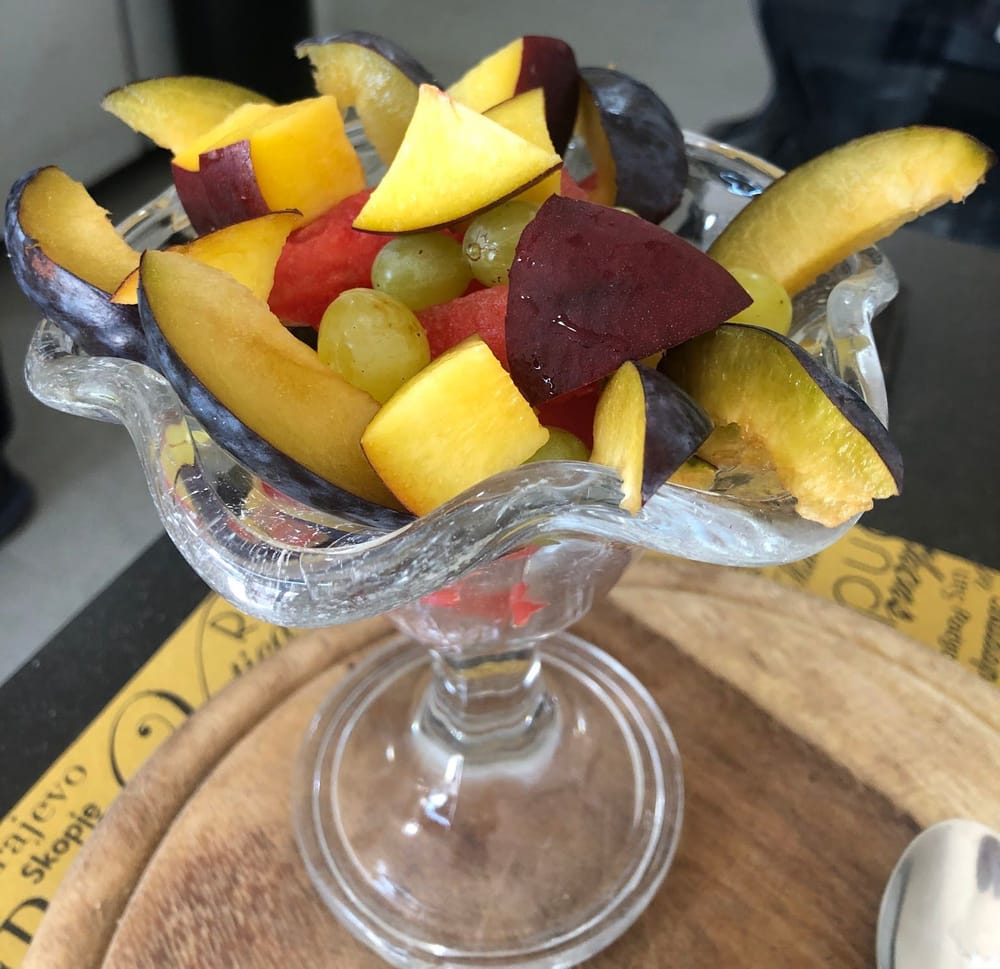 La frutta tagliata nel calice di vetro: prugne, pesca, uva e anguria.