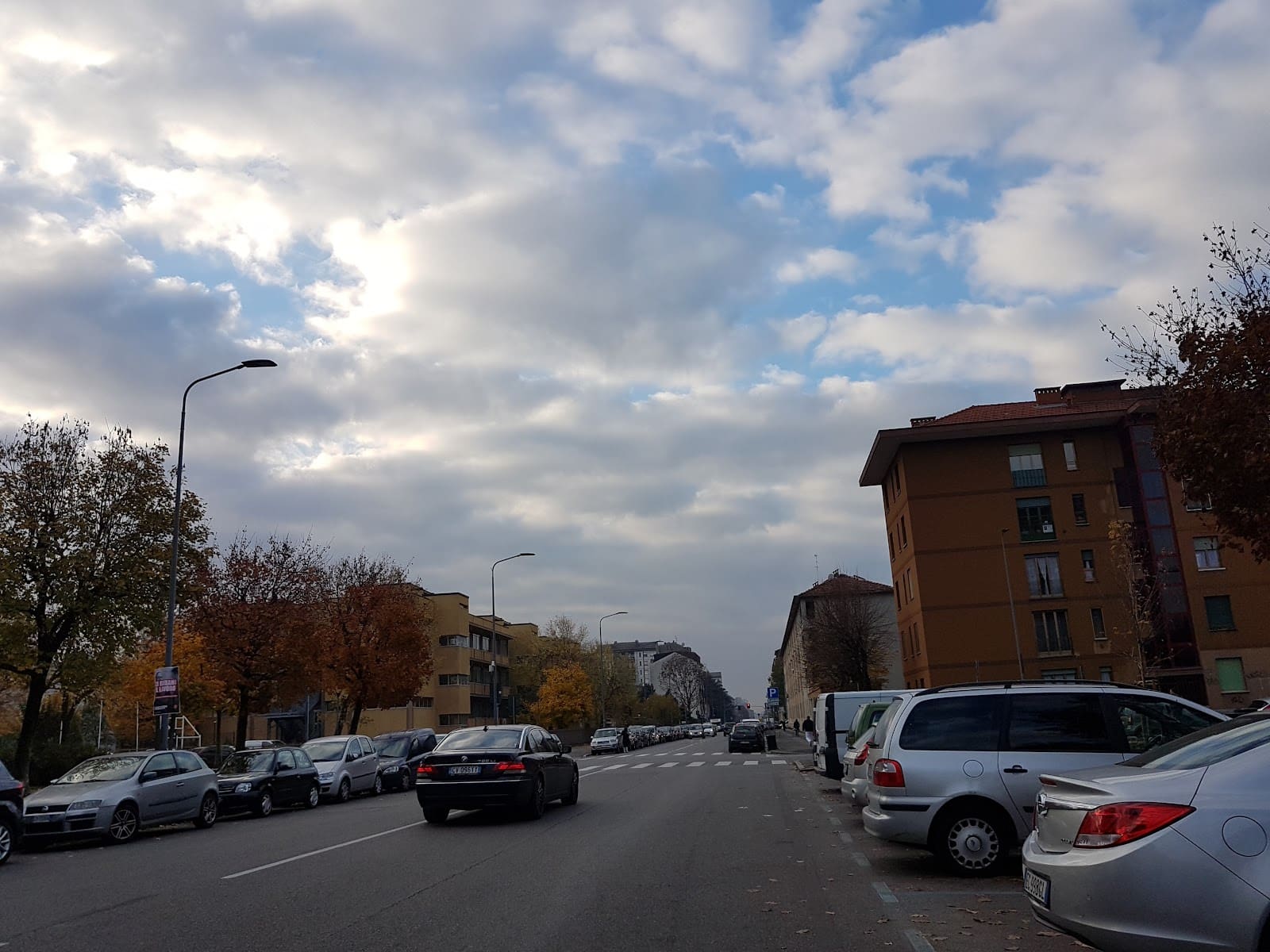 Viale Suzzani visto dal bar, con i palazzi e il cielo nuvoloso