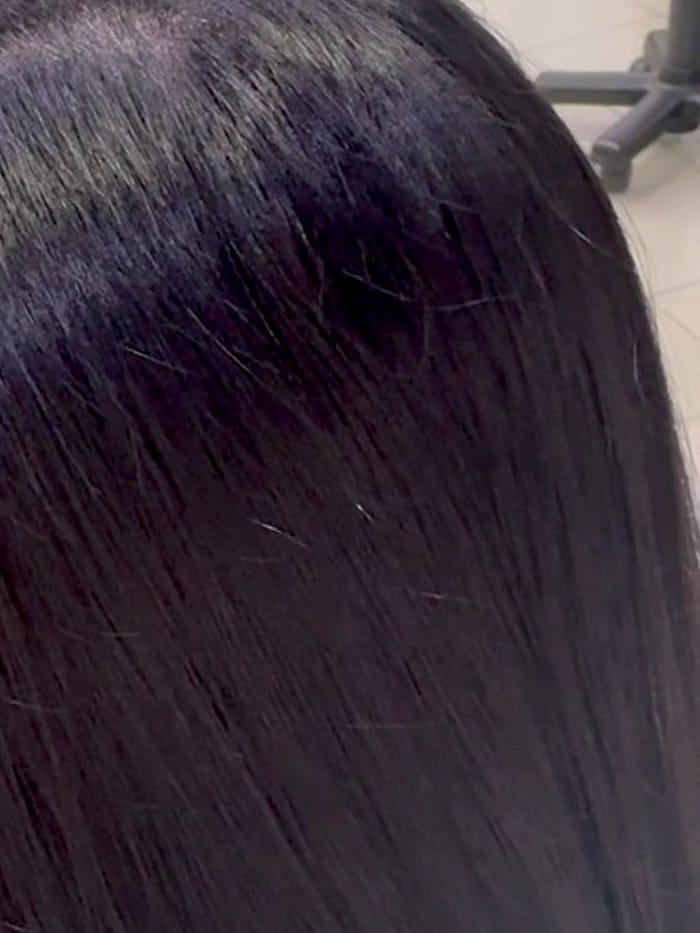 Capelli neri, lisci e lucidi, visti da dietro.