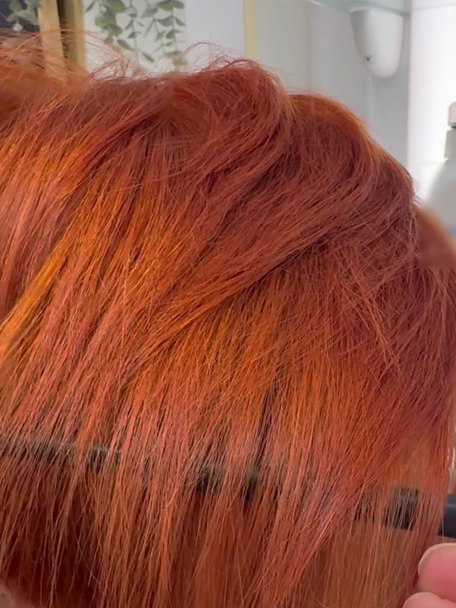 Un taglio corto color rame, col pettine che sistema il ciuffo.