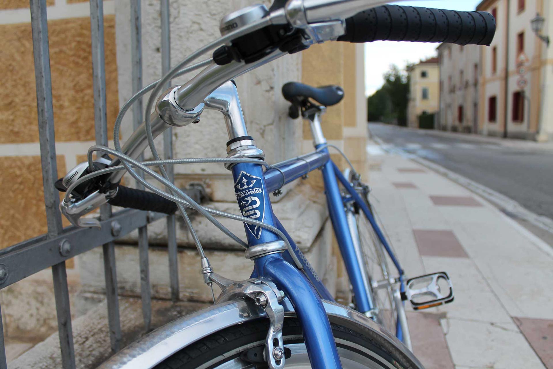 Dettaglio del manubrio di una city bike azzurra in strada