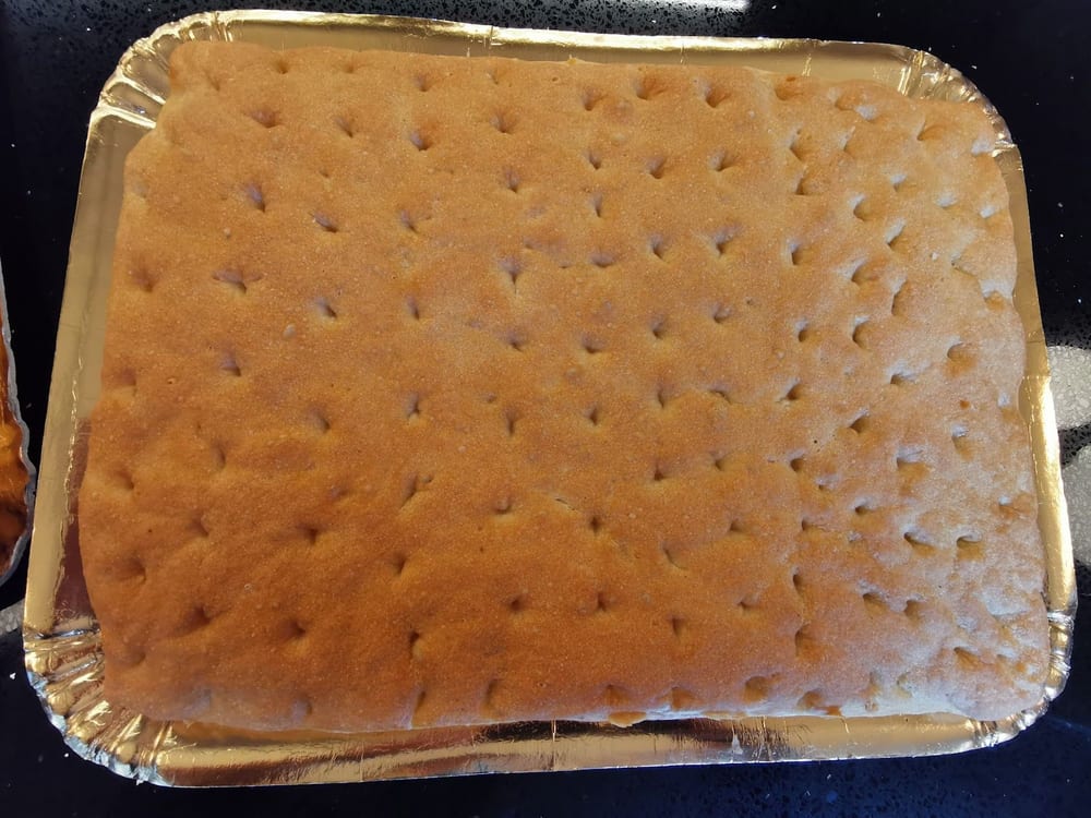Una focaccia intera nella teglia d'alluminio.