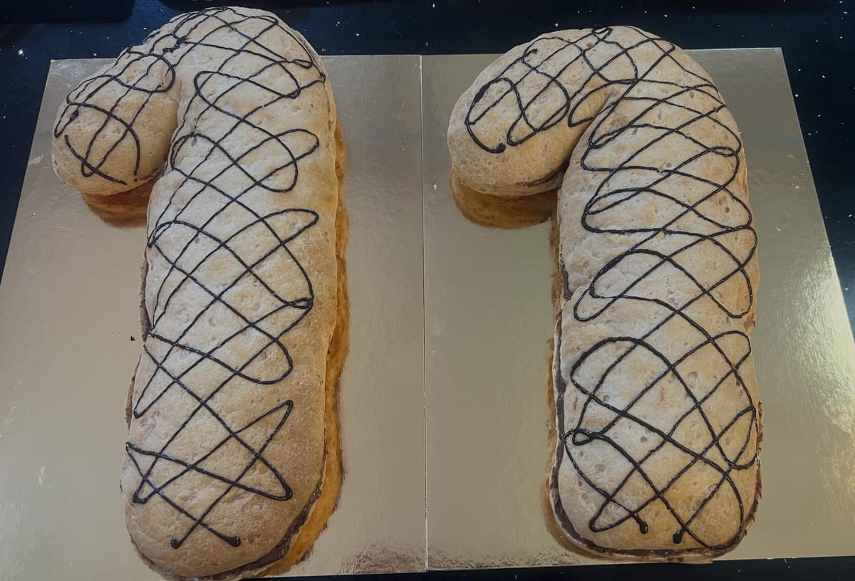 Una torta a numero «11», glassata coi fili di cioccolato, sui cartoni dorati.