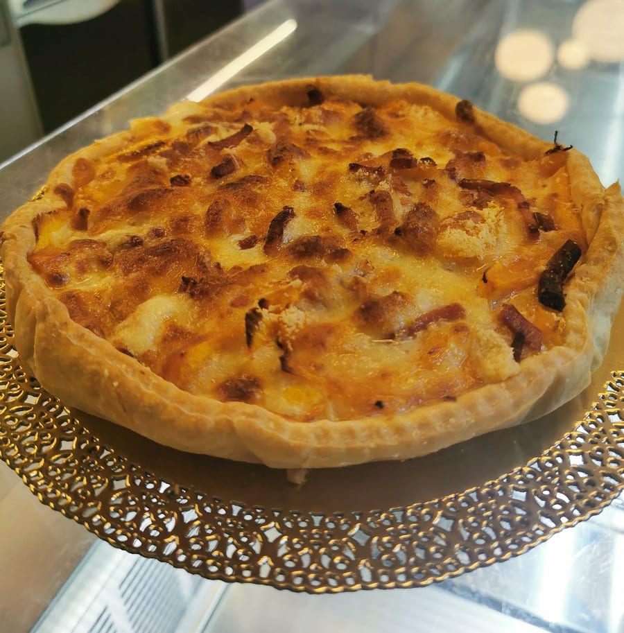 Una torta salata dorata sul centrino dorato.