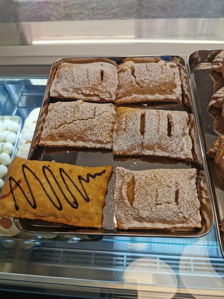 Sfoglie ripiene con i fili di cioccolato, in una teglia nel banco.