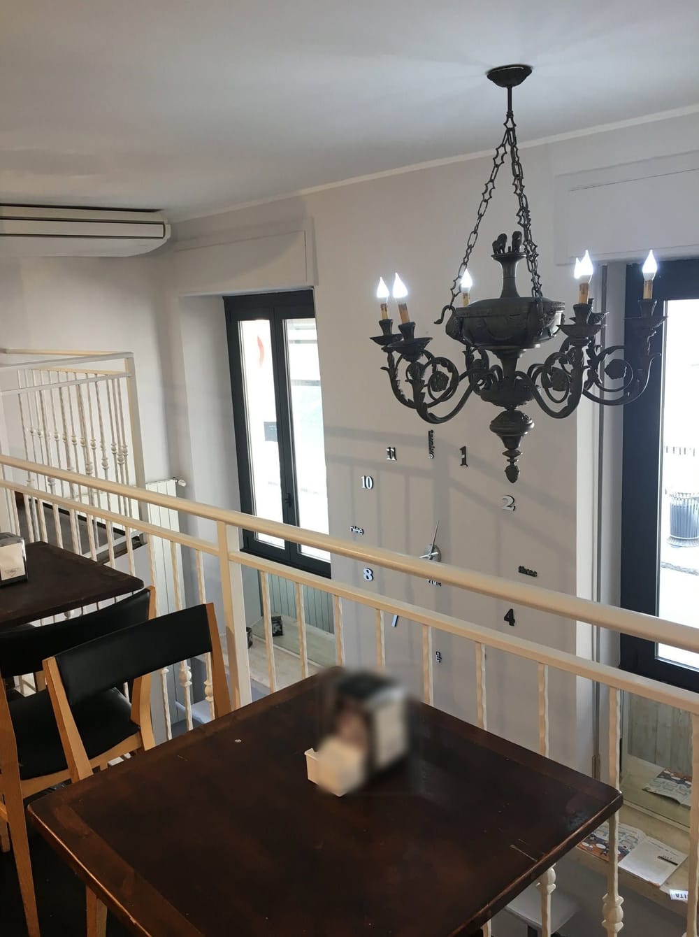 Il lampadario di ferro a candele sopra la ringhiera.