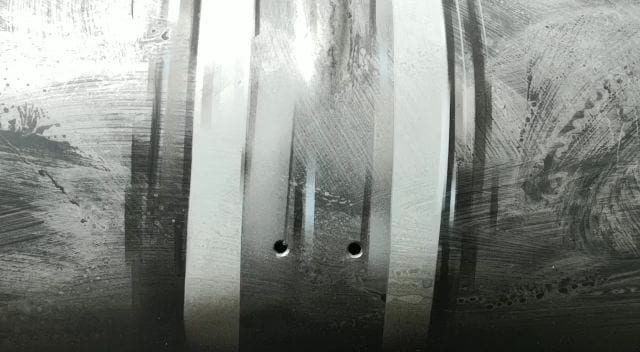 Le righe dei neon riflesse su un pannello di lamiera