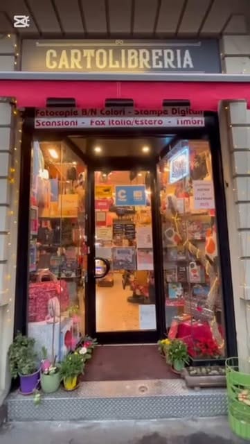 L'ingresso della cartolibreria di sera, con la vetrina illuminata