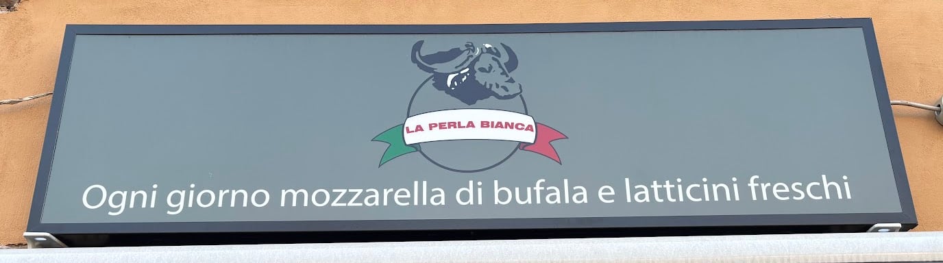 L'insegna grigia con il logo della bufala e la scritta: Ogni giorno mozzarella di bufala e latticini freschi