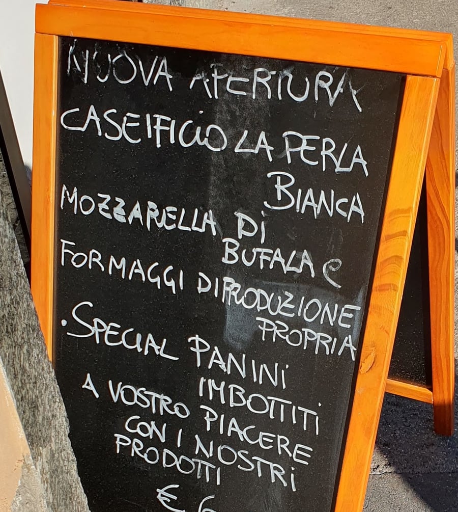 La lavagna fuori dal negozio: Caseificio La Perla Bianca, mozzarella di bufala e formaggi di produzione propria, special panini imbottiti con i nostri prodotti