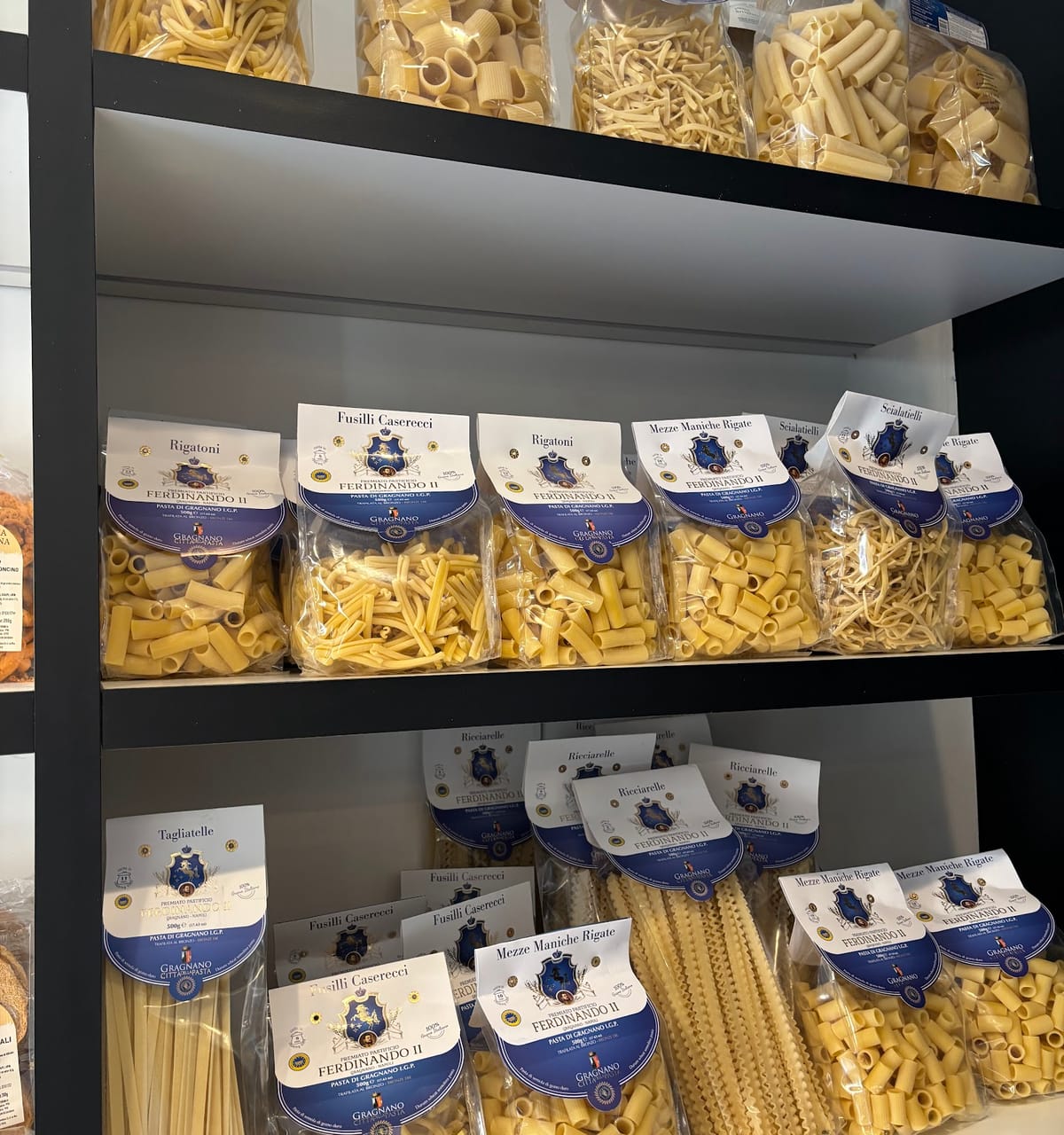 Gli scaffali del negozio con i pacchi di pasta e i taralli