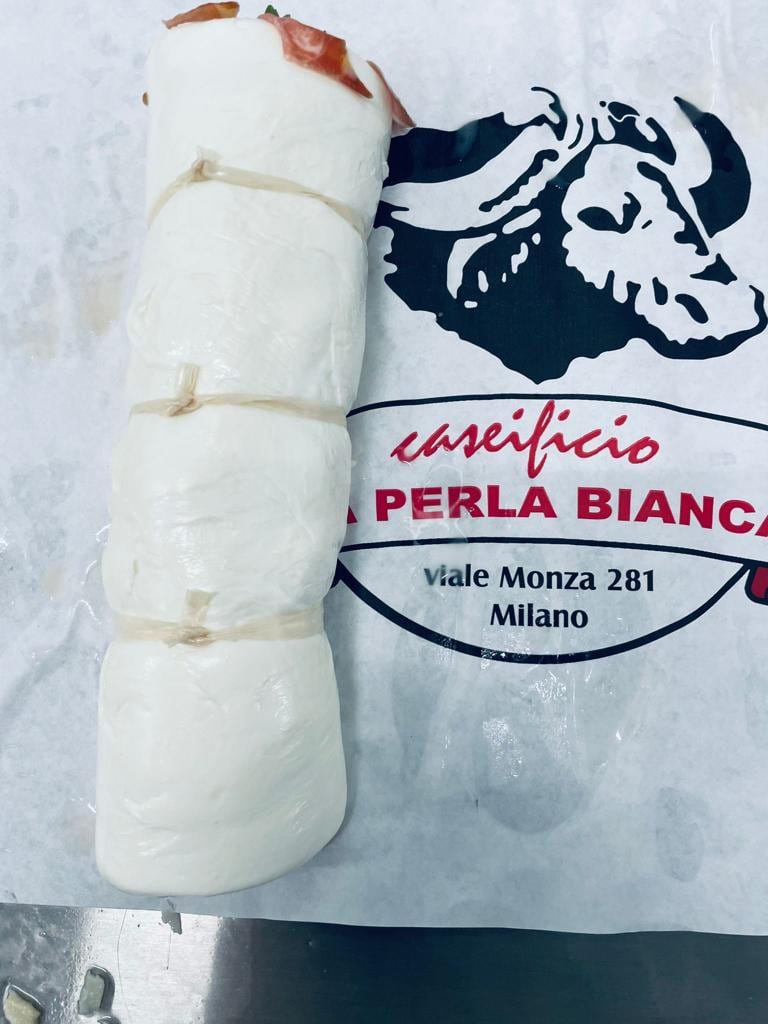 Una treccia di mozzarella legata con la rafia sulla carta con il logo della bufala e l'indirizzo Viale Monza 281