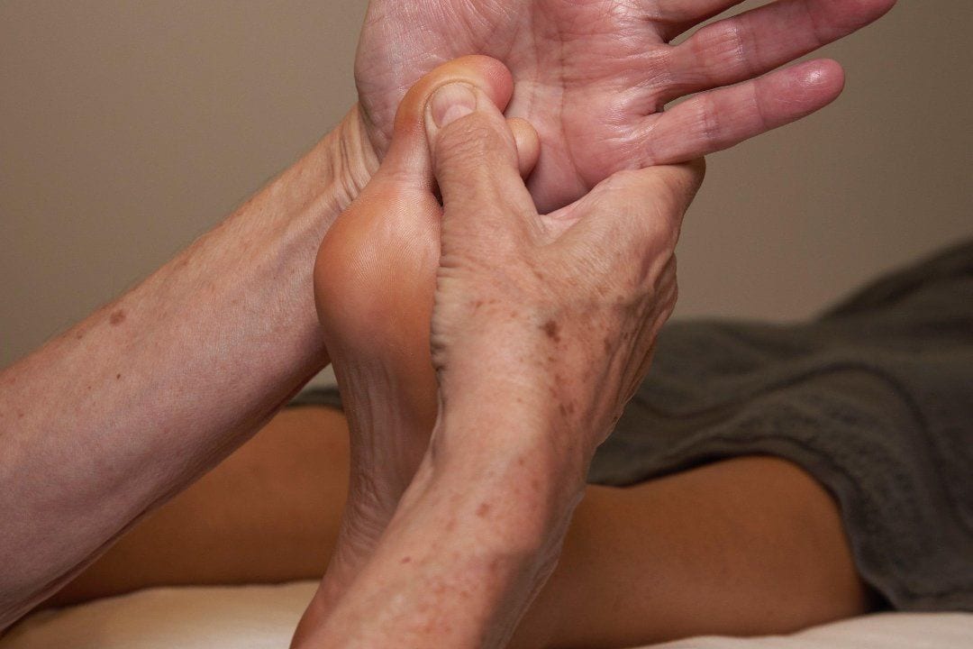La riflessologia plantare: le mani sulla pianta del piede.
