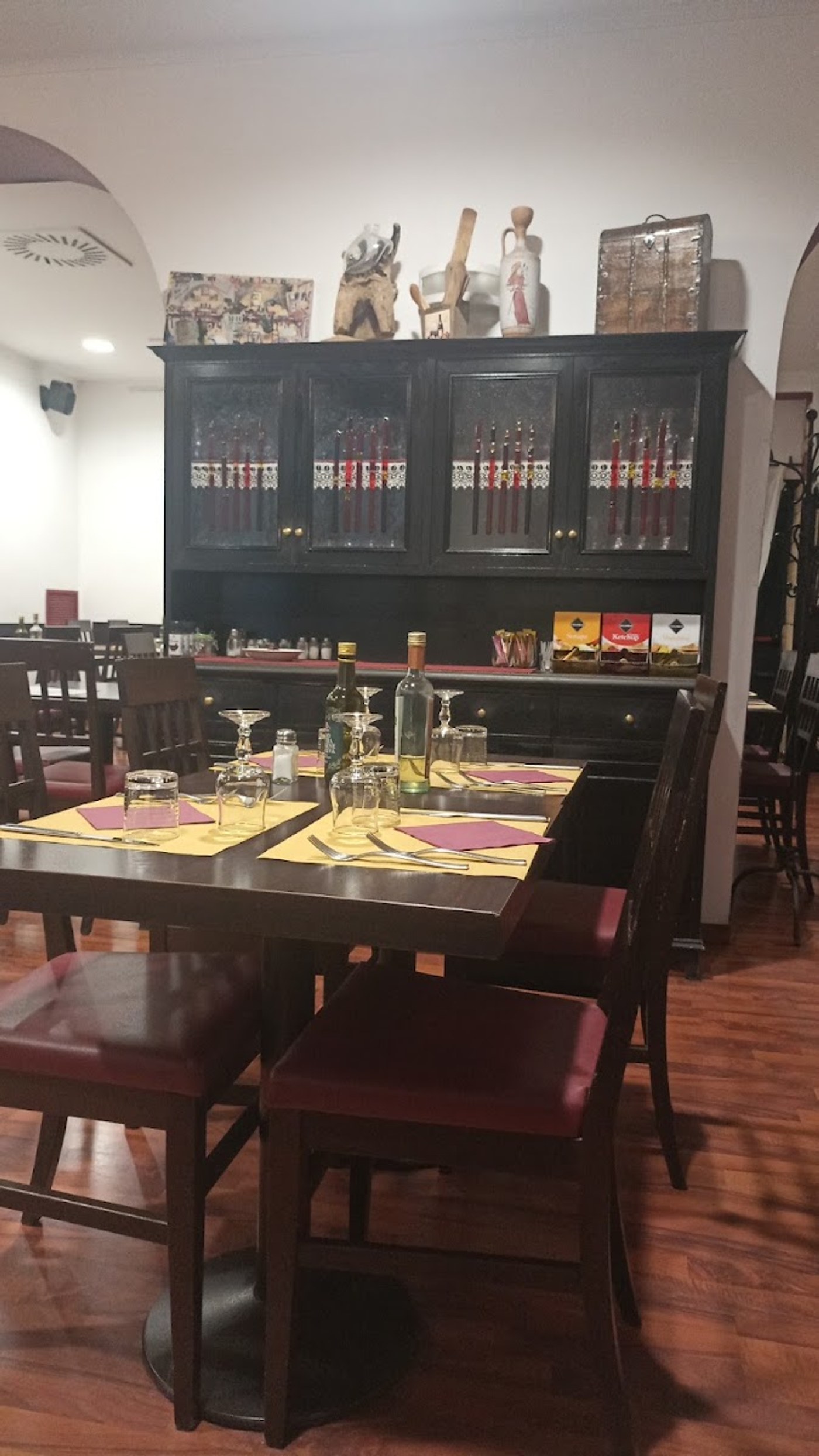 Un tavolo apparecchiato con le tovagliette gialle davanti alla credenza