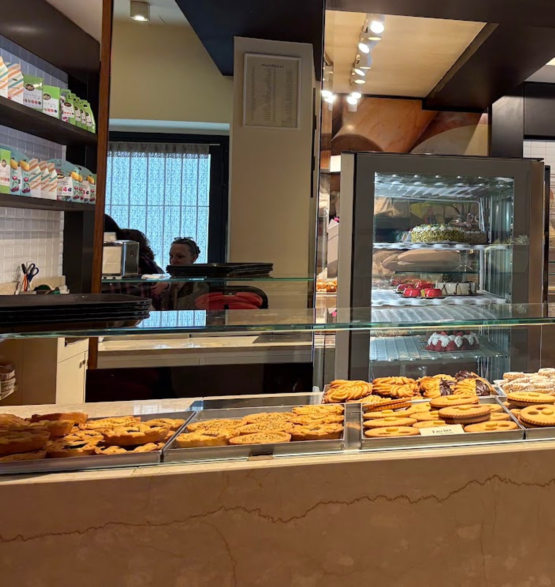 La sala: la pasticceria secca in primo piano e i cestelli del pane appesi al muro sul fondo