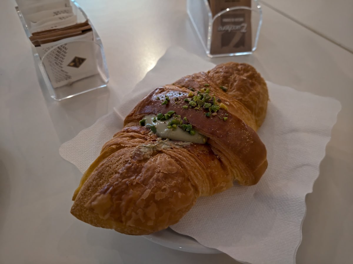 Un cornetto farcito con crema al pistacchio, servito al tavolino