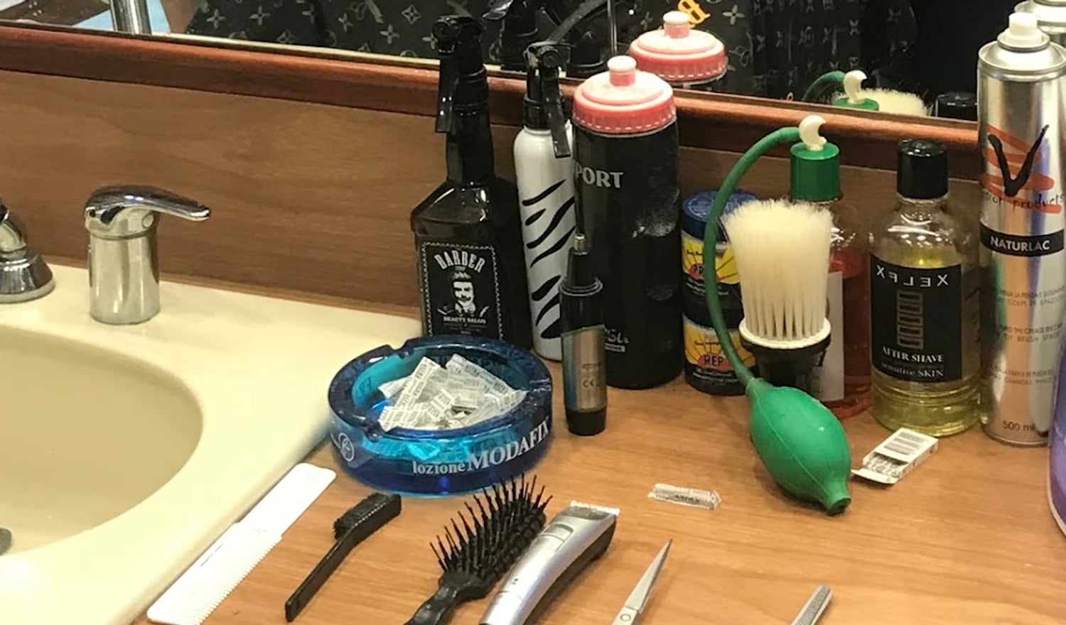 Il banco del barbiere: forbici, pettini, macchinetta, pennello da barba e lozioni