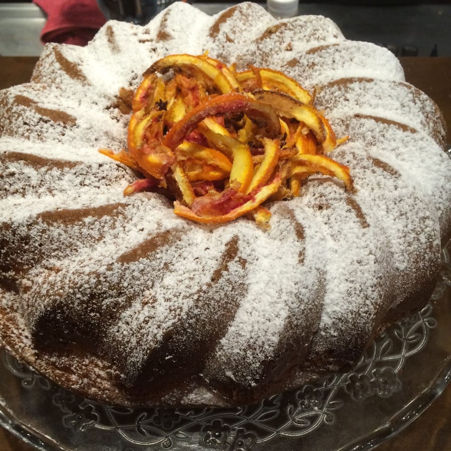 Una ciambella della casa con lo zucchero a velo e le scorze d'arancia.