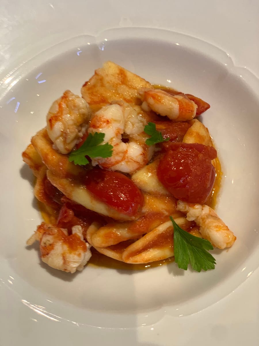 Un piatto di pasta coi gamberi e i pomodorini.