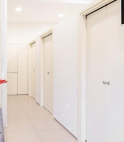 Il corridoio bianco con le porte delle cabine.