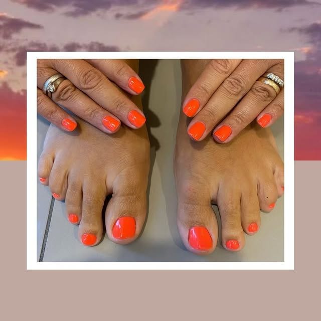 Mani e piedi con lo smalto arancio.