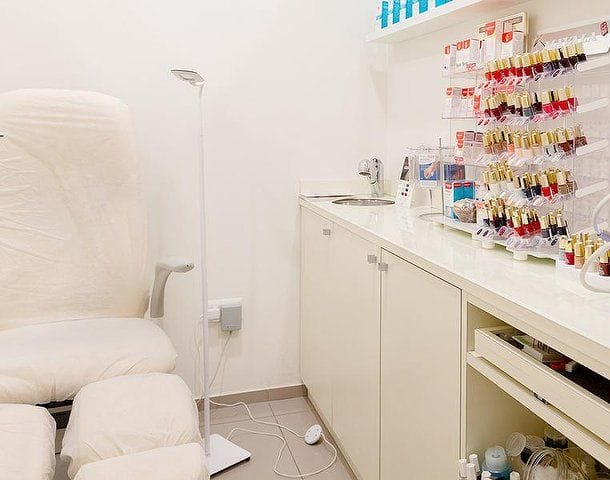 La poltrona della pedicure e la parete degli smalti.