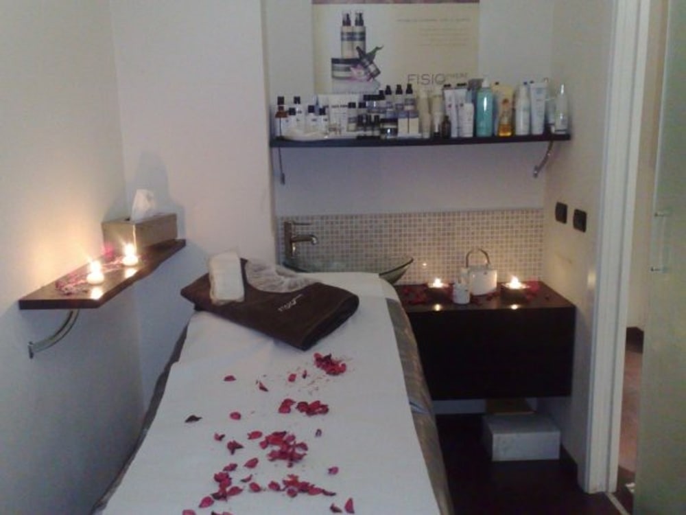 Una cabina apparecchiata per il relax, con petali di rosa e candele