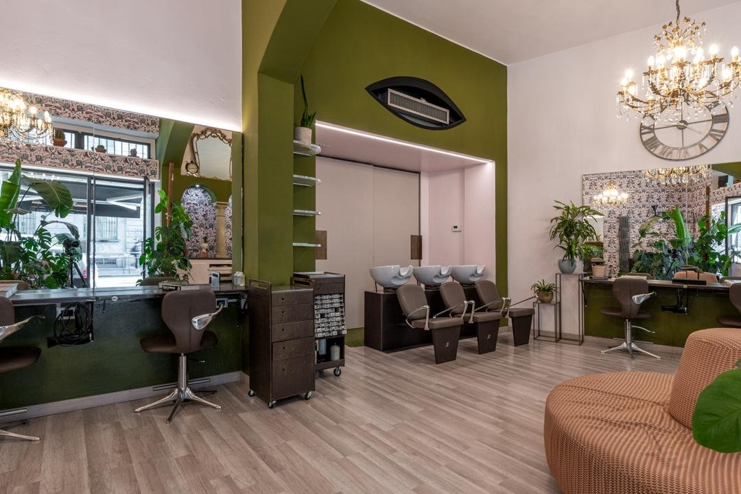 Sala con parete verde, lampadario e postazioni