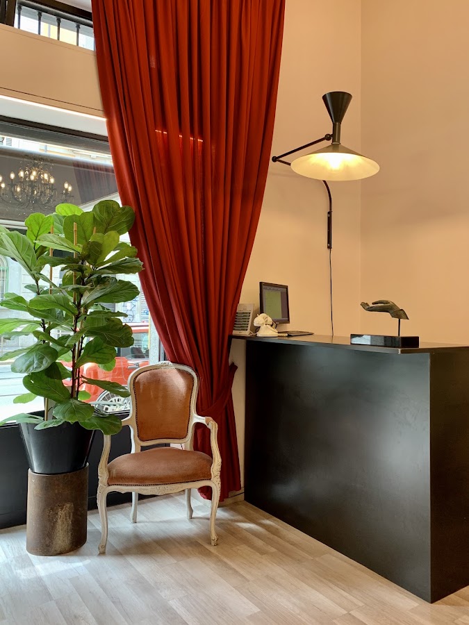 Dettaglio: tenda in velluto, poltrona vintage e ficus