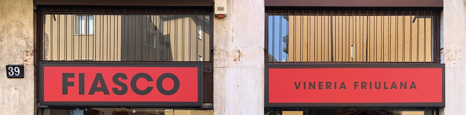 Le due insegne rosse del negozio: FIASCO e VINERIA FRIULANA, accanto al civico 39