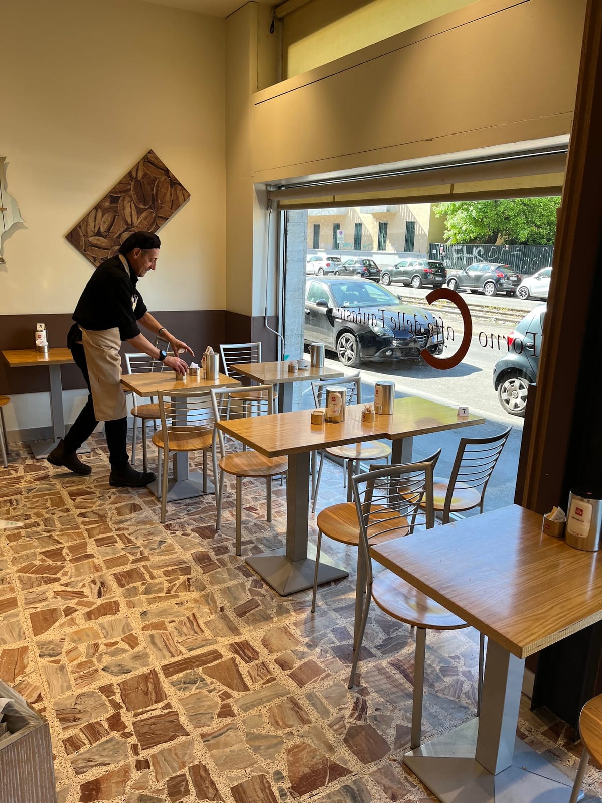 L'angolo caffè coi tavolini e la C del logo sulla vetrina