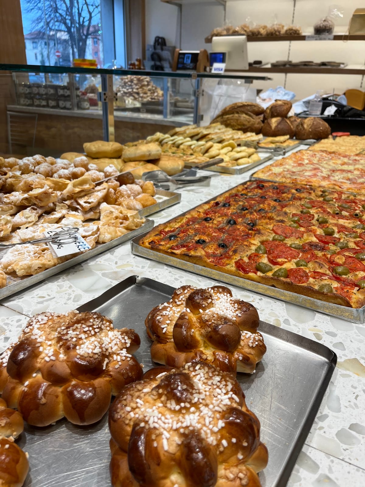 Il banco con brioches zuccherate, pizze al taglio e chiacchiere