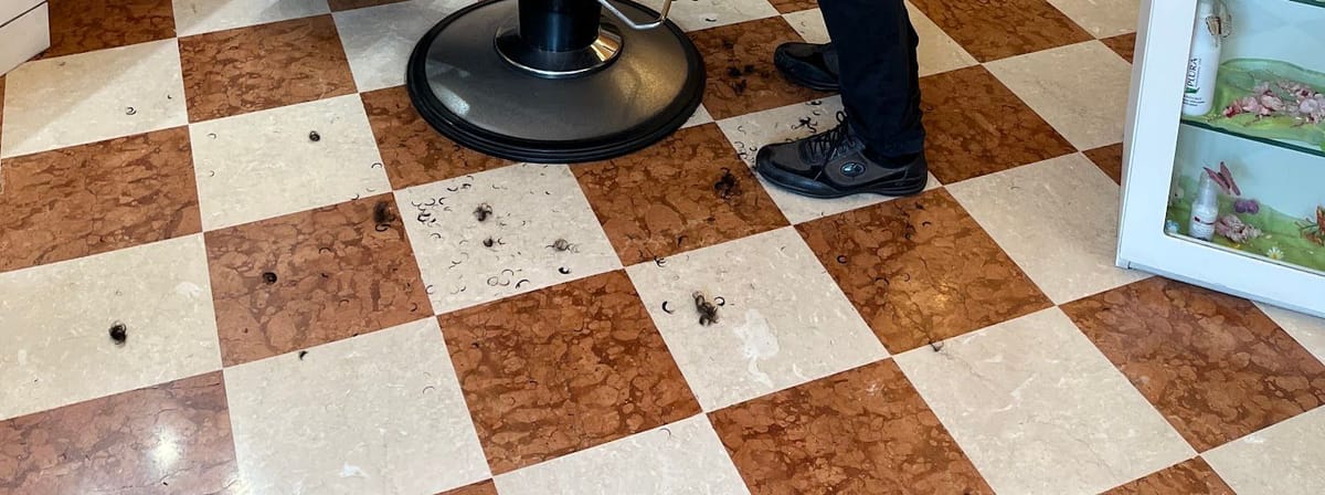 Il pavimento a scacchiera di marmo rosso e crema, posato in diagonale, con la base di una poltrona.