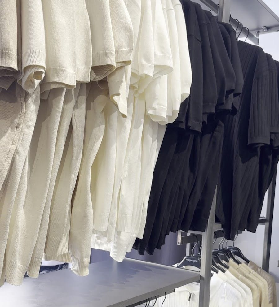 Camicie bianche e nere appese alle grucce con la scritta FREEMODE