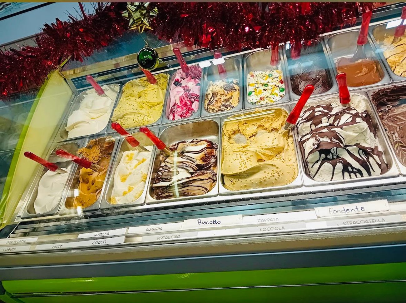 Il banco del gelato con le targhette dei gusti e le vaschette in fila