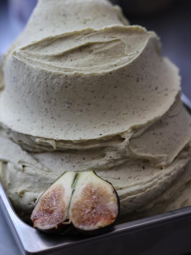 Il gelato al fico nella vaschetta, con un fico tagliato.