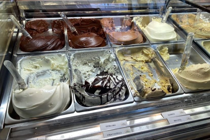 La vetrina dei gusti: il cioccolato, la stracciatella, il gianduia, il biscotto, coi loro cartellini.