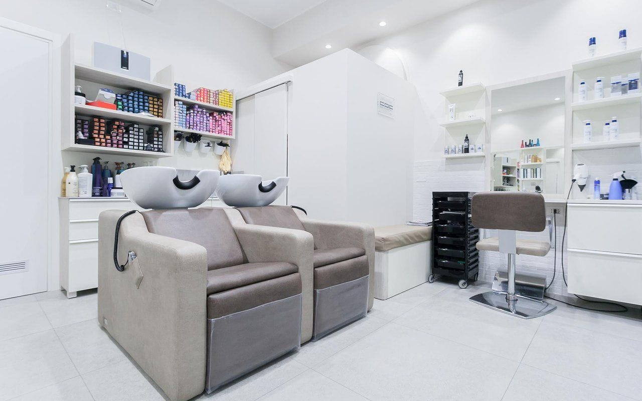 Il salone bianco: i lavatesta, le postazioni, le mensole.